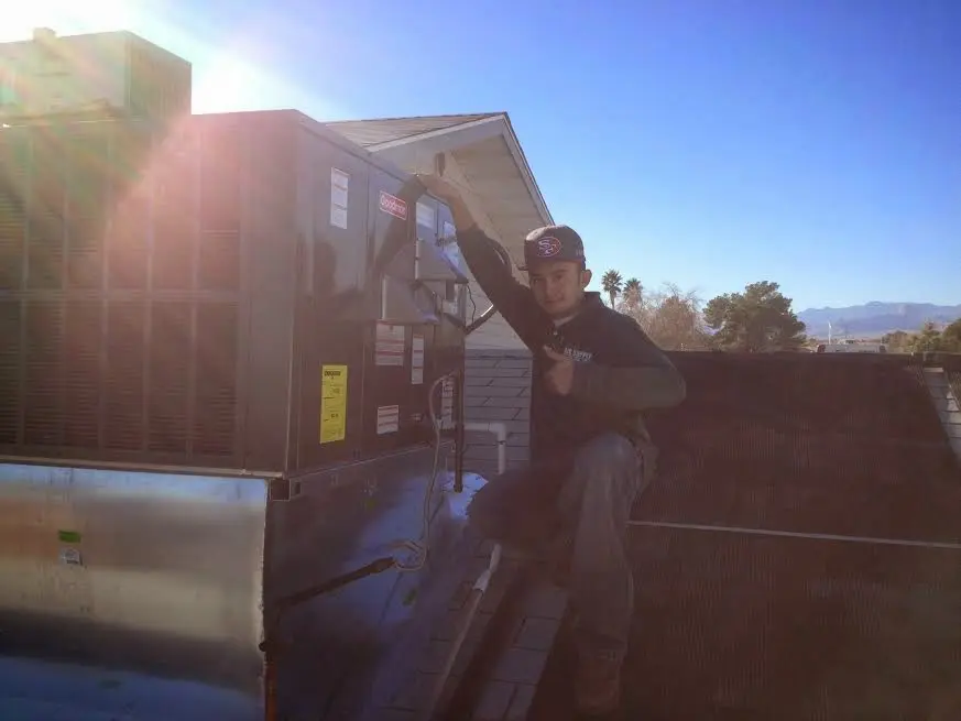 HVAC technician performing AC Tune-Up on a rooftop unit in Atherton